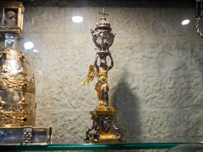 ...conservato in un tabernacolo di cristallo sovrastato da una croce d�argento e retto da un angelo in ottone